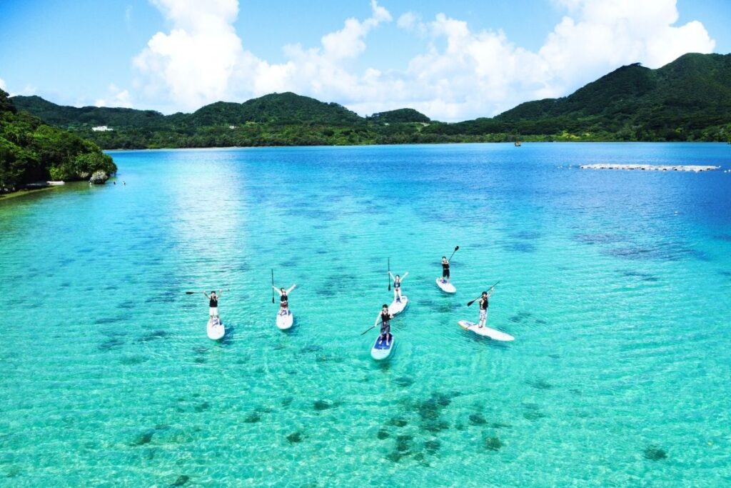 石垣島の壮大な山々とどこまでも続く青い海に囲まれた大パノラマの中を、少人数で一列になって進む贅沢なSUP体験ツアー