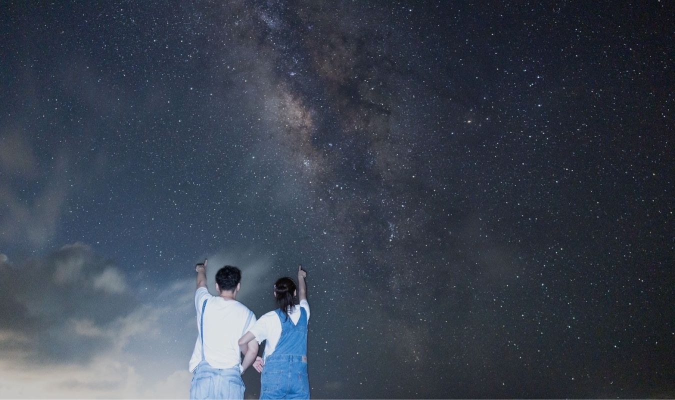 石垣島の一眼レフ星空フォトツアーでお揃いの服装で満天の天の川を指差すカップル