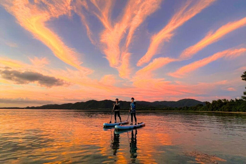 空いっぱいに広がる鮮やかなピンク色の夕焼け雲に見惚れながら、静かな水面を並んで進むサンセットSUPクルージング